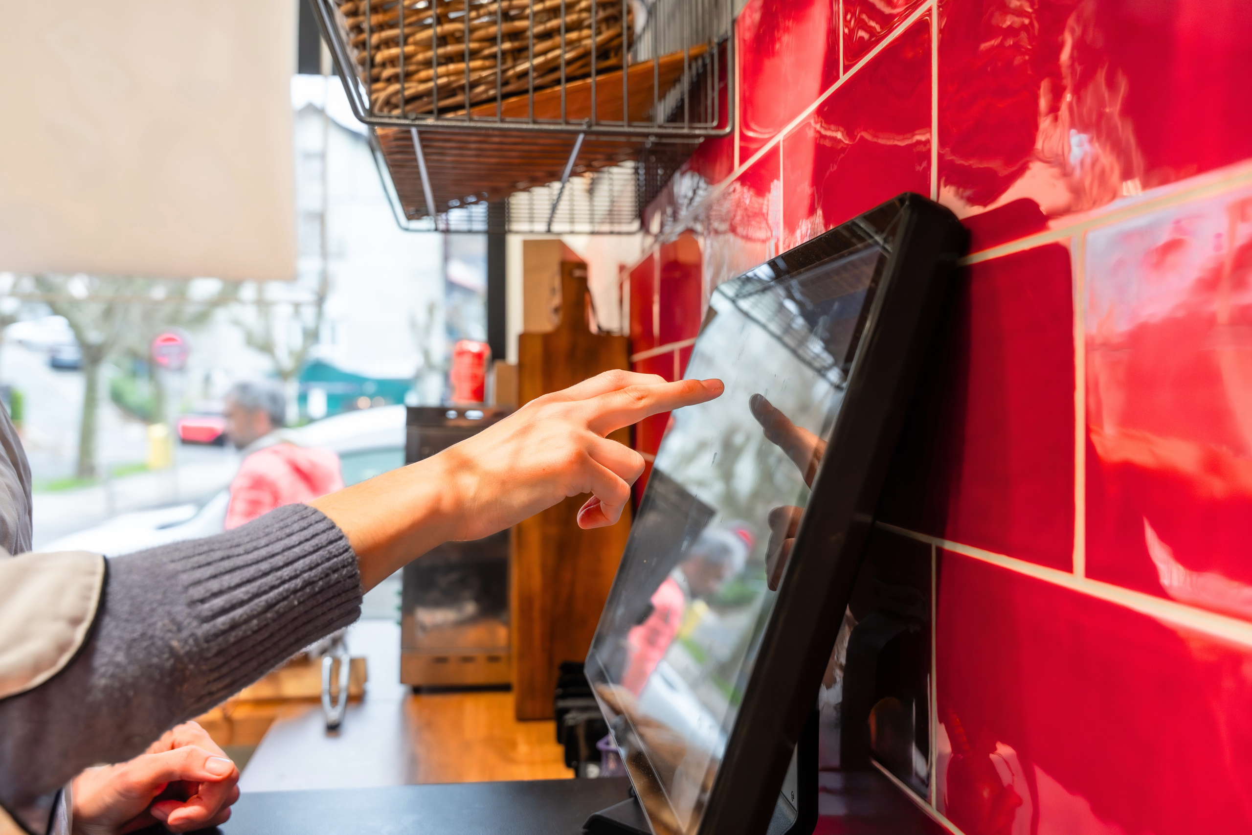 Customer using a touchscreen point of sale system, representing customer experience and sales process improvement opportunities