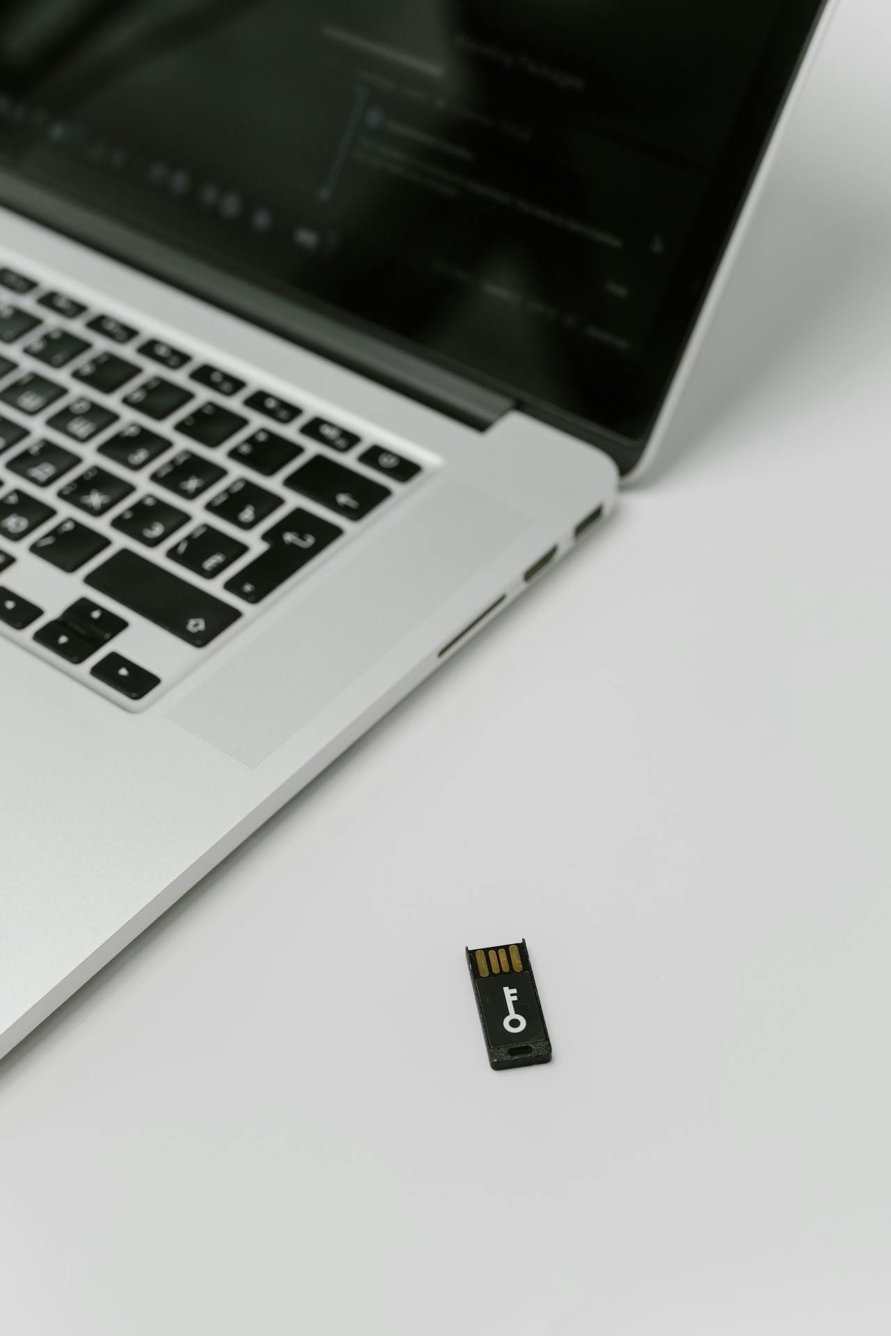 Laptop beside a hardware security key used for multi-factor authentication and protected account login