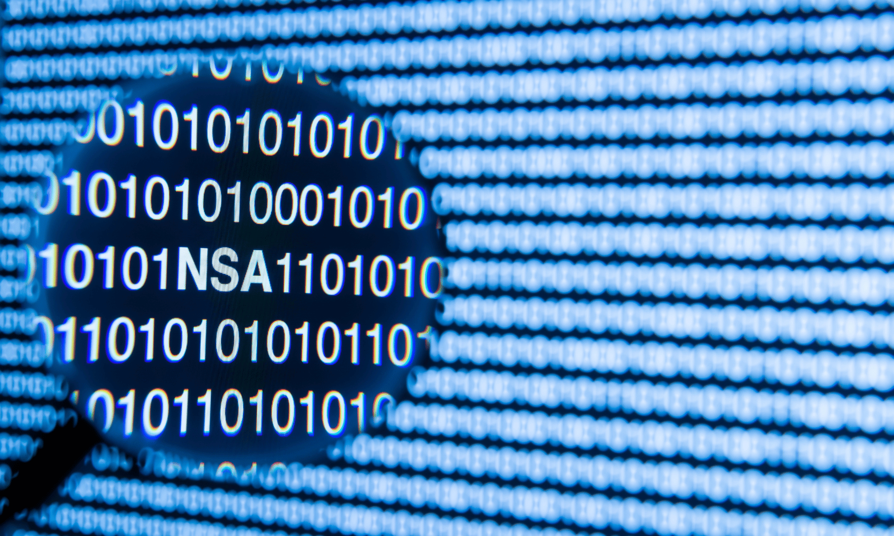 Binary code with NSA lettering under a magnifying glass, representing the Shadow Brokers leak and cybersecurity lessons for SMBs.