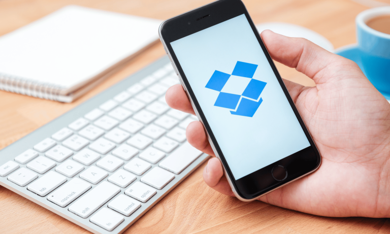 A person holding a smartphone with the Dropbox logo, representing Dropbox two-factor authentication for secure account access.